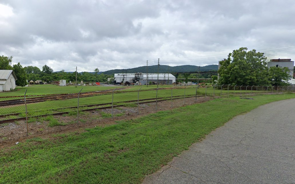 Cartersville, GA site — rail siding along the fence line with warehouse buildings beyond
